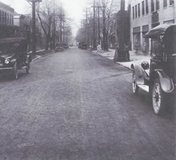 Model T cars parked on a wood block paved street